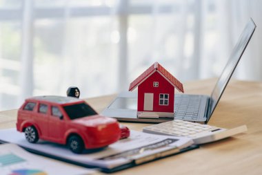 Ev modeli ve araba, dizüstü bilgisayar sözleşmesi masadaki belge, emlak işi konsepti