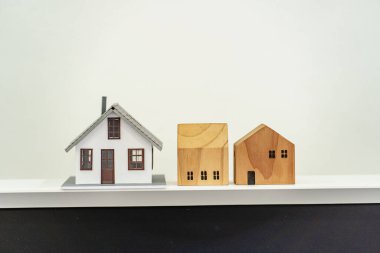Ofis masasında ahşap ev modeli. Yeni ev, finans, emlak sigortası ve gayrimenkul. Evin modeli masanın üstünde.