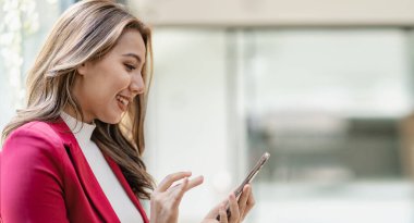 Ciddi Asyalı iş kadını müşteri hizmetlerini kullanarak masada oturuyor, satış müdürü ofisteki müşteriyle iş görüşmesi yapan bir kadına odaklanmış durumda.