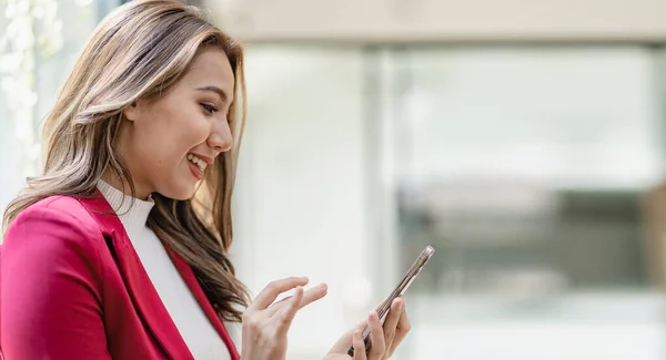 stock image Serious asian businesswoman using customer service phone sitting at table, sales manager focused woman on mobile business phone discussing work with customer in office