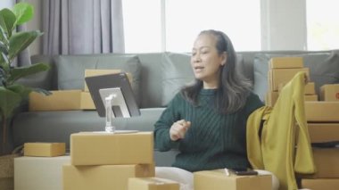Olgun bir kadın iş kuruyor, KOBİ sahibi, bayan girişimci çalışıyor ve evdeki tablet dizüstü bilgisayarla online siparişi kontrol ediyor. KME iş konsepti çevrimiçi paket teslimatı 4k