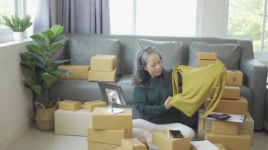 Olgun bir kadın iş kuruyor, KOBİ sahibi, bayan girişimci çalışıyor ve evdeki tablet dizüstü bilgisayarla online siparişi kontrol ediyor. KME iş konsepti çevrimiçi paket teslimatı 4k