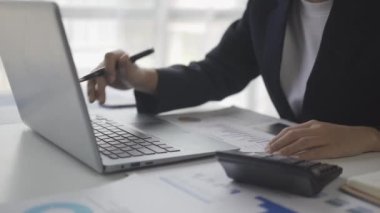 Finansal analist, şirket toplantısında başarılı takım çalışmalarını tartışırken iş finans raporunu grafik kağıdında analiz ediyor. 4k