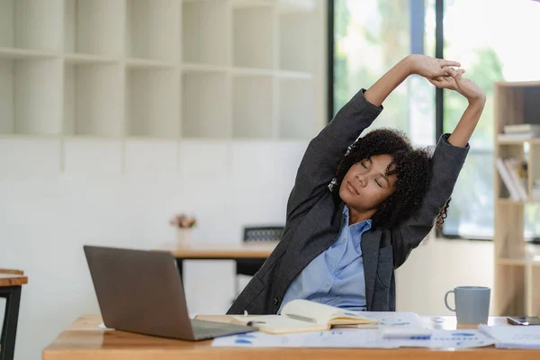 stock image Young african american businesswoman relaxing with hands at office tired employee sitting at desk feeling tired back muscle tension after work