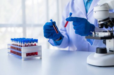 Tıbbi araştırmacı ve mavi lateks eldivenler mikropları önlemek için bir hastanın kan damarlarının laboratuardaki araştırma deneylerine götürüldüğünü gösteriyor..