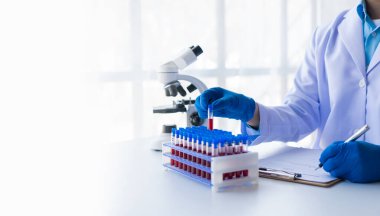 Tıbbi araştırmacı ve mavi lateks eldivenler mikropları önlemek için bir hastanın kan damarlarının laboratuardaki araştırma deneylerine götürüldüğünü gösteriyor..