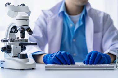 Laboratuvarda mavi sıvıyla laboratuvar analiz tüpünde saydam çözelti test tüpüne bakan tıbbi veya bilimsel araştırmacı veya erkek doktor.
