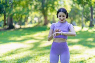 Genç Asyalı kadın egzersiz ve sağlık için bahçede yoga yapıyor. Parkta Asyalı kadın yoga yapıyor ve yazın yeşil parkta spor kıyafetleriyle rahatlıyor.