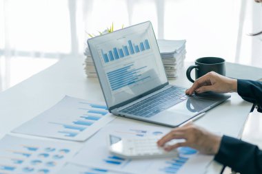 Muhasebeci, ofis muhasebe konseptindeki finans raporunu hesaplamak için hesap makinesini kullanır, iş adamı ise ofiste bilgisayar, bütçe ve kredi kağıdı kullanarak hesap makinesi kullanır..