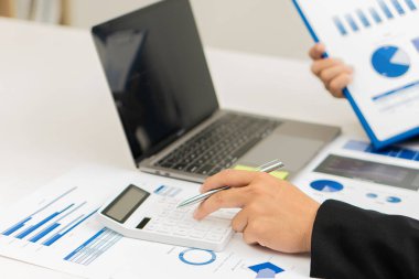 Muhasebeci, ofis muhasebe konseptindeki finans raporunu hesaplamak için hesap makinesini kullanır, iş adamı ise ofiste bilgisayar, bütçe ve kredi kağıdı kullanarak hesap makinesi kullanır..