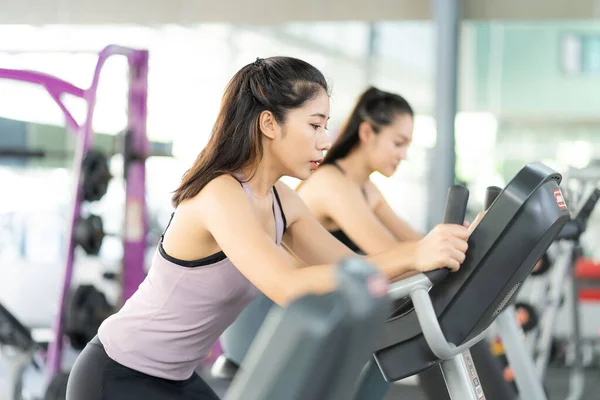 ジムでフィットネスの練習中に水を飲むアジアの2人の女性と健康的なライフスタイルを重視した板ワークアウトや健康トレーニングを行う女性の運動 — ストック写真