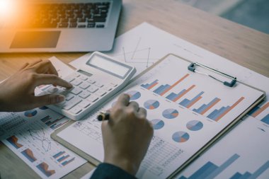 Muhasebeci elinde kalem tutuyor ve ofis vergisi, muhasebe, istatistik ve analitik araştırma konsepti, iş finansmanı gibi ahşap masa üzerinde şirket vergisi yapıyor.