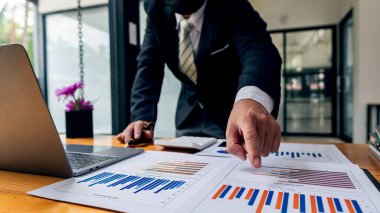 Muhasebeci elinde kalem tutuyor ve ofis vergisi, muhasebe, istatistik ve analitik araştırma konsepti, iş finansmanı gibi ahşap masa üzerinde şirket vergisi yapıyor.