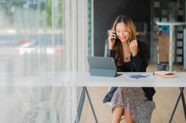 Masada dizüstü bilgisayarla çalışan iş kadını Asyalı kadın muhasebeci ya da bankacı ofisteki finans ve finans ekonomisi kavramını hesaplıyor.