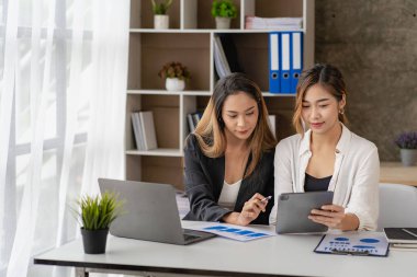 İş kadını, iş arkadaşlarının önünde sunum yapıyor. İş kadını danışman, şirket grup eğitiminde finansal tabloları, dizüstü bilgisayarları ve finansal evrakları açıklıyor.