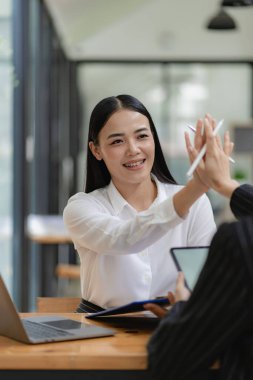 İş kadını, iş arkadaşlarının önünde sunum yapıyor. İş kadını danışman, şirket grup eğitiminde finansal tabloları, dizüstü bilgisayarları ve finansal evrakları açıklıyor.