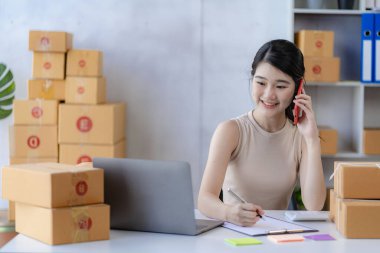 Çekici Asyalı kadın küçük bir iş kuruyor, KME girişimcisi, posta kutusuyla dağıtım deposu. Sahibinin küçük ev ofisi çevrimiçi pazarlama ve ürün ambalajlama ve ev dağıtım hizmetleri.