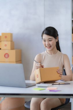 Çekici Asyalı kadın küçük bir iş kuruyor, KME girişimcisi, posta kutusuyla dağıtım deposu. Sahibinin küçük ev ofisi çevrimiçi pazarlama ve ürün ambalajlama ve ev dağıtım hizmetleri.