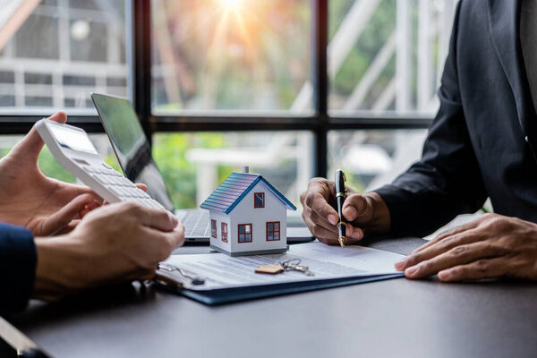 Real estate agents recommend interest rates, discuss the terms of the home purchase agreement, and ask clients to sign paperwork to legalize the contract.