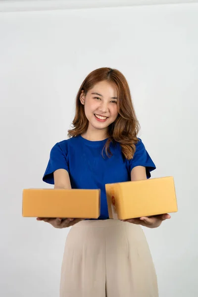 Happy asian woman holding parcel boxes doing various gestures isolated on white background Delivery and courier service concept