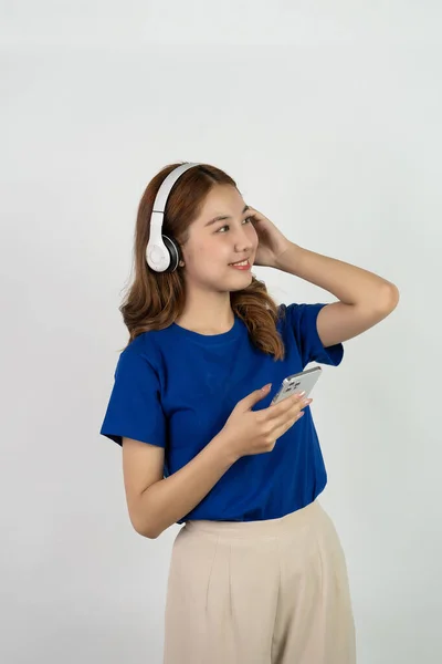Adorable Asian Girl Holding Smartphone Wearing Headphones While Listening Music — Stock Photo, Image