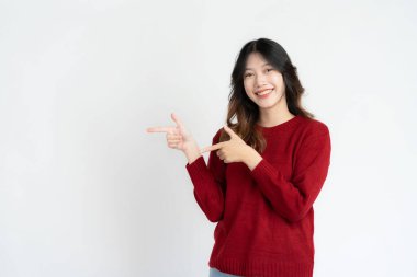 Çekici Asyalı güzel kadın beyaz arka planda duruyor ve el hareketleri yapıyor..