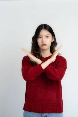 Çekici Asyalı güzel kadın beyaz arka planda duruyor ve el hareketleri yapıyor..
