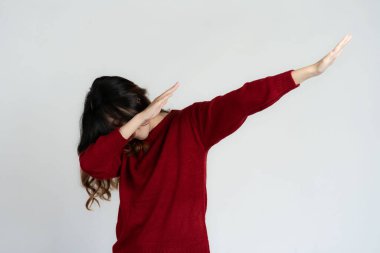 Çekici Asyalı güzel kadın beyaz arka planda duruyor ve el hareketleri yapıyor..