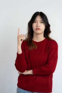 Çekici Asyalı güzel kadın beyaz arka planda duruyor ve el hareketleri yapıyor..