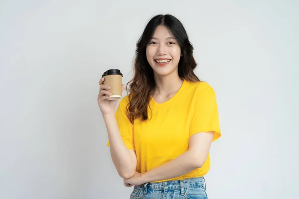 Sorridente Ragazza Asiatica Camicia Gialla Possesso Tazza Caffè Piedi Sfondo — Foto Stock