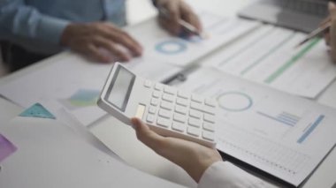 İstatistiksel analiz planı toplantısına katılan iki Asyalı işadamı ve takım lideri dizüstü bilgisayarlı grafiklere işaret ederek finansal başarı istatistikleri kavramını not alıyor. 4k video