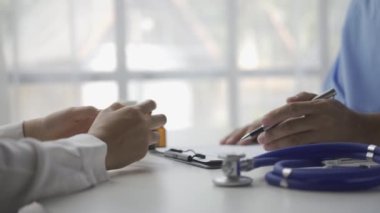 Bir erkek doktor hastalığını sorar ve konuşur ve hastanede kadın hastaların dostane bir şekilde tedavi edilmesi konusunda tavsiyelerde bulunur..