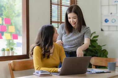 Evde hesap makinesi ve dizüstü bilgisayarla finans yapan iki Asyalı kız arkadaş. Evrak işleri, para ve dizüstü bilgisayarda daktilo formu üzerinde çalışıyorlar. Ev işleri konsepti.