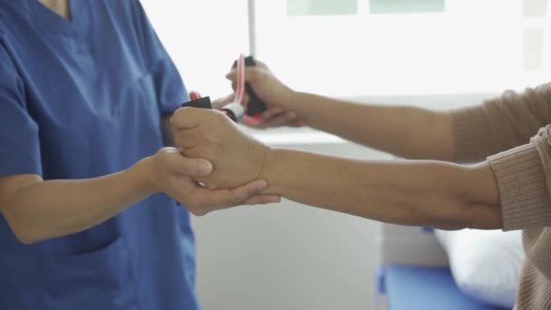 Junge Physiotherapeutin Gespräch Und Zeigt Grauhaarige Alte Frau Armbewegungen Mit — Stockvideo