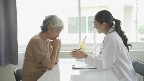 의사가 환자와 상담하고 산부인과 전문의 의사가 테이블에 노인의 병력을 — 비디오