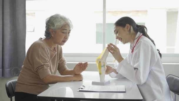 Médico Mujer Consultando Paciente Anciano Dando Prescripción Sentado Mesa Clínica — Vídeos de Stock