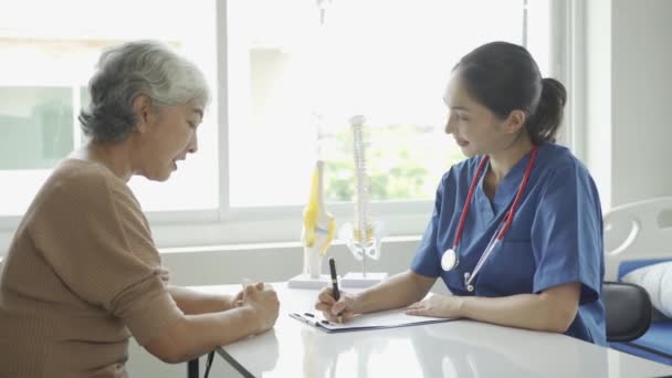Kvinnlig Läkare Konsulterar Äldre Patienter Och Ger Recept Sittande Vid — Stockvideo