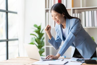 Ürünleri internetten sat. Özel Asyalı kadın. Satış başarısından memnun ve heyecanlı. Çevrimiçi zaferi, başarıyı, mutlu genç bayanı iyi haberlerle kutluyoruz.