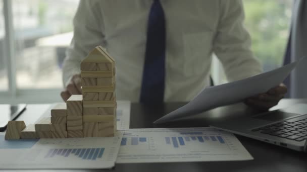 リスクと戦略ビジネスのアジアの男性ビジネスマン木製のブロックで塔を構築し 不動産ビジネスの成功の概念 — ストック動画