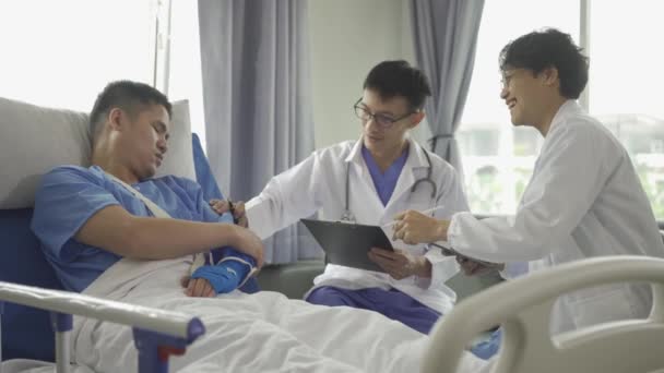 Twee Aziatische Mannelijke Artsen Bezoeken Verzorgen Een Mannelijke Patiënt Kamer — Stockvideo