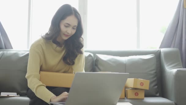 アジアのビジネスウーマンは オンラインで販売し 製品パッケージを確認するラップトップ 電話で注文を受け 輸送パッケージに注意を払う ホームオフィス女性起業家 中小企業事業 — ストック動画