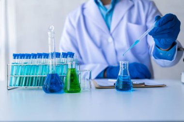 Tıbbi bilim teknolojisi araştırmaları kimya laboratuarı deneyleri üzerinde cam kaplama ve test tüplerinde mavi sıvı ile tıbbi ilaç deneyleri..