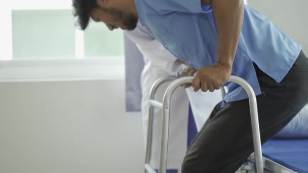 スポーツ理学療法アジアの男性医師の近くの手理学療法士は 歩行者や家で杖を歩く筋骨格損傷のトレーニングを持つ患者 — ストック動画