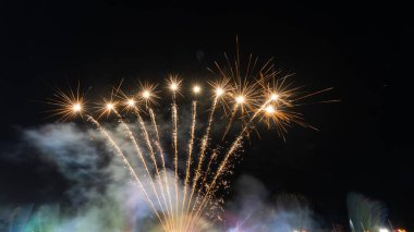 Yeni yıl havai fişekleri ve koyu mavi gökyüzü arka planında Bokeh ışıkları izole edilmiş altın kıvılcımlar ve havai fişeklerden oluşan bir çerçevede veya sınırda havai fişekler..