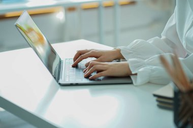 Genç kadın çevrimiçi iş arıyor dizüstü bilgisayarla çalışıyor, masada boş ekran ve bilgisayar elleriyle çalışmayı kapat.