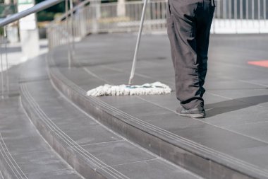 Personel ofisin önündeki yerleri paspaslamak için yerleri paspaslıyor..