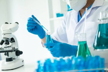 Tıbbi, analitik, tıbbi, ilaç ve bilimsel araştırma konseptleri için sıvıyla cam laboratuvarda kimyasal test tüpleri olan bir araştırmacı tıbbi araştırma klinikleri ve kimyasalları test tüpleri