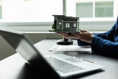 Ajanlar örnek evleri müşterilere teslim eder. İpotek anlaşmaları, krediler, kiralama anlaşmaları ve ev satışları. Gayrimenkul konsepti Sigorta sözleşmeleri ve yasal anlaşmalar