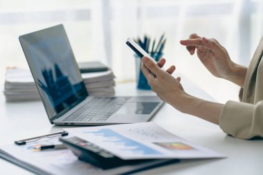 İş kadını akıllı telefon kullanımı yıllık gelir ve giderleri analiz ve hesaplama, bir mali tablo ve mali rapor, teknoloji ve işsizlik kavramı.