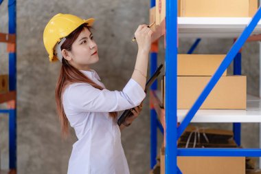 Asyalı iş kadını dizüstü bilgisayarını kullanarak evde müşteri siparişlerini kontrol ediyor. Küçük bir işletme KOBİ kuruyorum. Bağımsız girişimci Çevrimiçi iş, paket dağıtım kavramı